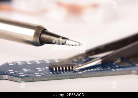 Small electronics integrated circuit IC on empty printed circuit board ready for hand assembly Stock Photo