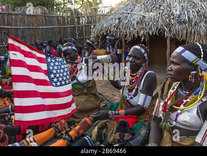 Larim tribe women with an american flag during a wedding celebration, Boya Mountains, Imatong, South Sudan Stock Photo