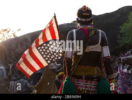 Larim tribe woman with an american flag during a wedding celebration, Boya Mountains, Imatong, South Sudan Stock Photo