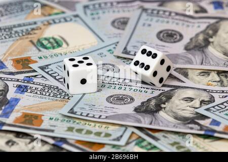 two white dice on 100 dollar bills. concept of gambling, financial, stock market investment risk and return Stock Photo