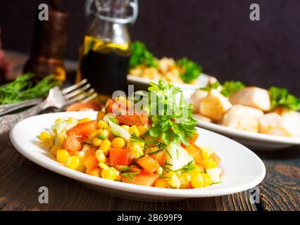 chicken roasted with vegetables and  bulgur sauce and fresh vegetable salad on wooden background Stock Photo