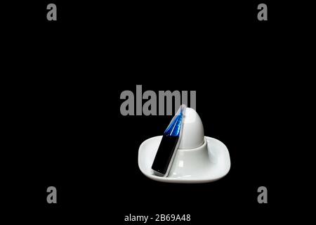 white fresh hen's egg in an egg cup, blue egg colouring is next to it Stock Photo
