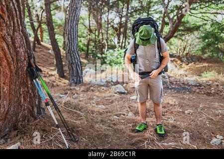 stylish hipster traveler exploring map alone in forest, modern trekking and hiking concept Stock Photo