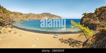 Group of young people having fun and hugging on the beach together. Vacation with friends in Turkey concept Stock Photo