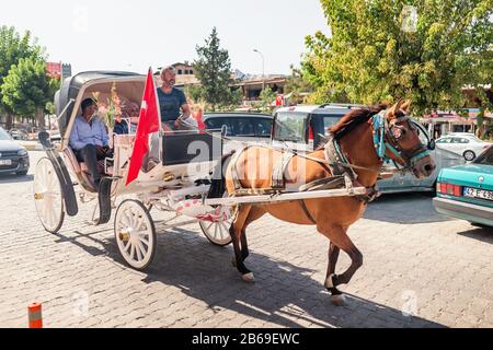 23 SEPTEMBER 2017, GOREME, TURKEY: Tourists travelling with horse drawn coach at summer in Cappadocia Stock Photo