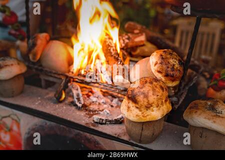 traditional Turkish Testi Kebab cooked in clay pot on open fire at night in restaurant, authentic oriental cuisine Stock Photo