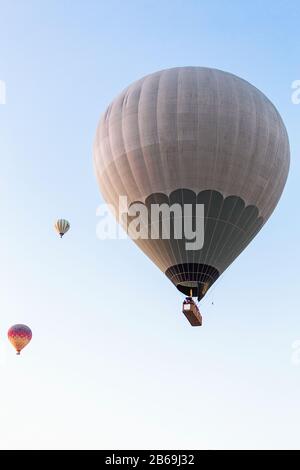 Many unrecognizable colorful hot air balloons against blue sky Stock Photo