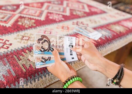 SEPTEMBER 2017, GOREME, CAPPADOCIA, TURKEY: Woman holding two tickets to open air Zelve museum, concept of tourist trip Stock Photo