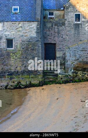 Old house on a beach with stairs and a door Stock Photo