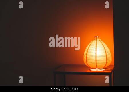 House decoration: Orange lamp on a table in the dark Stock Photo