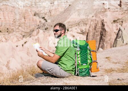 Man tourist in mountain read the map at hot season Stock Photo