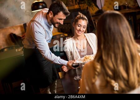 The waiter carries dishes in modern restaurant Stock Photo