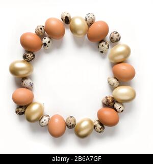 Easter creative modern wreath of golden, quail, chicken eggs isolated on white background. View from above. Space for text. Stock Photo