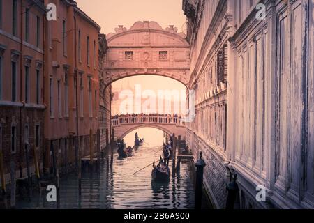 Gondolas row down a canal towards Bridge of Sighs in Venice, Italy on a cold Winter afternoon in December Stock Photo