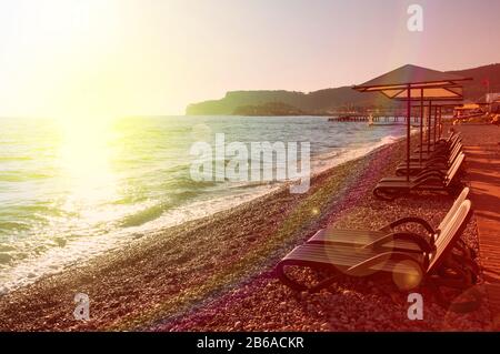 Sunshades and chaise lounges on beach. Summer seascape. Beautiful seaview. Turkey, Kemer.