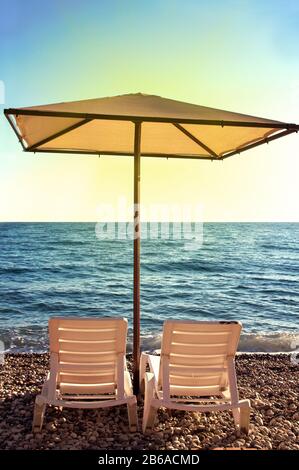Sunshades and chaise lounges on beach. Summer seascape. Beautiful seaview