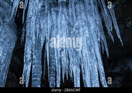 Crystal clear sharp icicles hanging down on the mountain Stock Photo