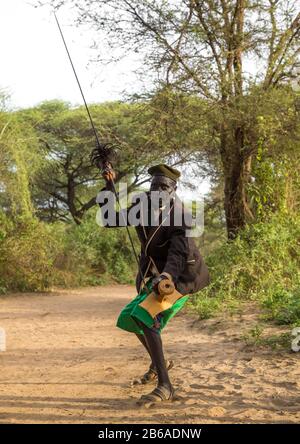 Toposa tribe man dancing with a spear and a wooden seat, Namorunyang State, Kapoeta, South Sudan Stock Photo