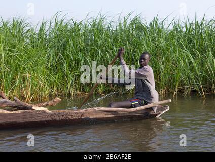 Mundari tribe man rowing in a boat on river Nile, Central Equatoria, Terekeka, South Sudan Stock Photo