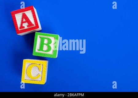 Wooden ABC blocks on blue background Stock Photo
