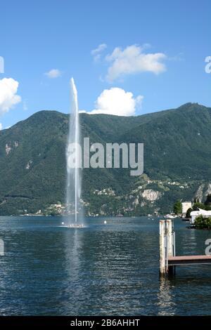 PARADISO, SWITZERLAND - JULY 5, 2014: Monte Sighignola rises behind the fountain in Lake Lugano. Despite being surrounded by Lugano, Paradiso is indep Stock Photo