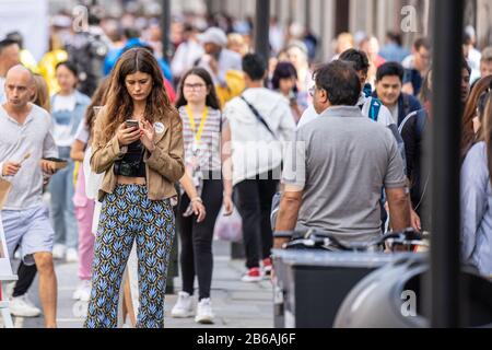 London, UK, July 14, 2019. London woman on smart phone shopping, texting on mobile phone Stock Photo