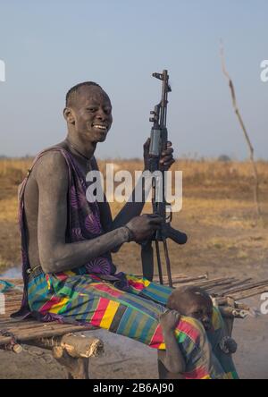Mundari tribe man with a Kalashnikov in a cattle camp, Central Equatoria, Terekeka, South Sudan Stock Photo