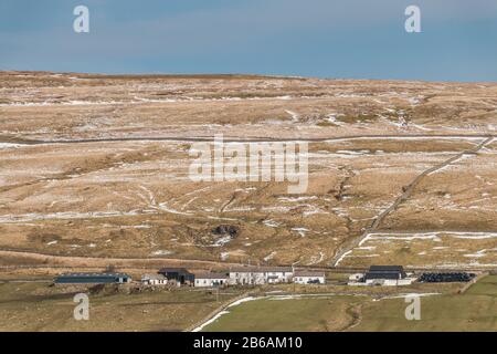 A patchy snow covered hillside emphasizing the landscape features behind Bowes Close Farm, Harwood, Upper Teesdale, UK Stock Photo