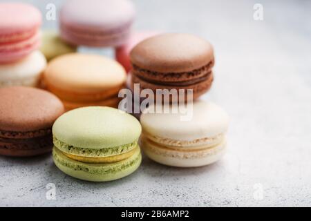 Multicolored macaroni cookies lie on a gray stone slab. Still-life of confectionery products. Stock Photo