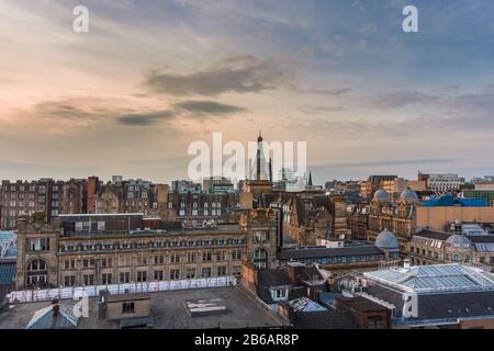 A wide rooftop view looking out over the buildings and architecture of Glasgow city centre at sunset, Scotland Stock Photo