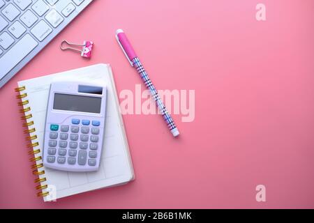 top view of calculator, notepad and pen on pink background  Stock Photo