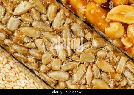 Assorted kozinaki, sweets from sunflower seeds, sesame and peanuts filled with brilliant glaze. Macro Stock Photo