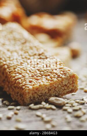 Sweets Bar of sesame on a vintage background with burlap. Delicious oriental sweets Gozinaki from sunflower seeds, sesame and peanuts, covered with Stock Photo