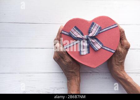top view of senior women holding heart shape gift  Stock Photo