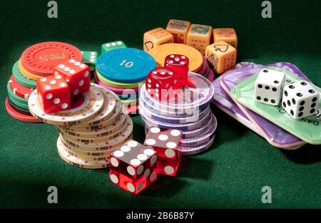 A collection of gambling chips, counters, dice and poker dice. Risk and reward. Stock Photo