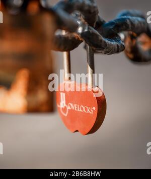 Closeup of a padlock hanging on chain link of the bridge / Fence Stock Photo