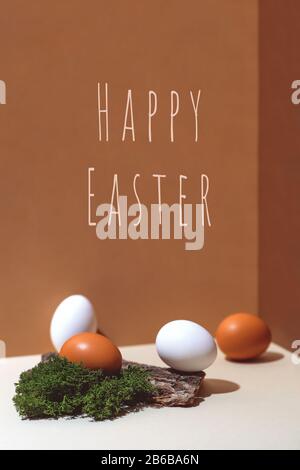 Four multi-colored eggs and natural materials moss and wood. Easter concept. Stock Photo