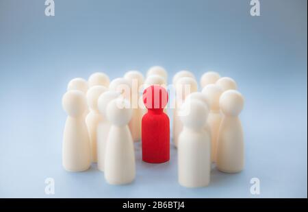 A socially diverse person being surrounded and protected by a crowd of people for being different. Coronavirus infected person self isolating Stock Photo