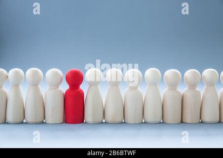 A row of human figures with a single individual standing out from the rest representing individuality and being different such as having a disease lik Stock Photo