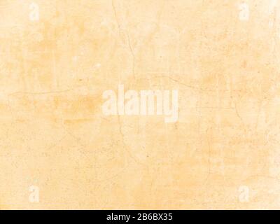 The texture of the cement wall with the chipped old antique plaster. Abstract background painted in beige and yellow Stock Photo