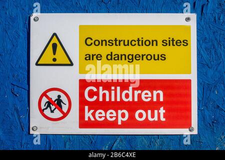 Construction sites are dangerous children keep out sign on a blue background Stock Photo