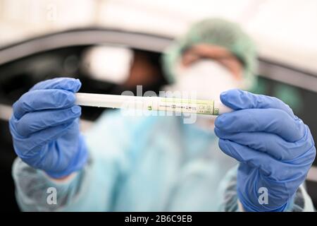 Oberteuringen, Germany. 10th Mar, 2020. A doctor holds a swab in a plastic tube in her hands after taking a smear from a patient's throat under a tent in a test centre on the outskirts of town. The smear is then tested for the novel coronavirus. Credit: Felix Kästle/dpa/Alamy Live News Stock Photo
