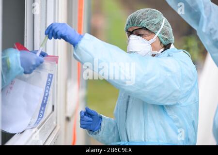 Oberteuringen, Germany. 10th Mar, 2020. A doctor puts a swab in a plastic tube into a plastic bag after taking a swab from a patient's throat under a tent in a test centre on the outskirts of town. The swab is then tested for the novel coronavirus. Credit: Felix Kästle/dpa/Alamy Live News Stock Photo