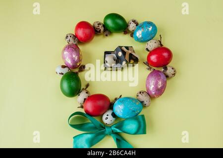 Gift and painted eggs Easter Frame in circle shape on a yellow background. Copy space, Top view Stock Photo