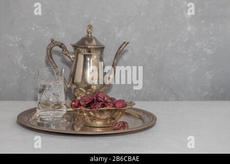 Ramadan fasting concept. Water and dry dates on vintage tray on neutral background with copy space Stock Photo