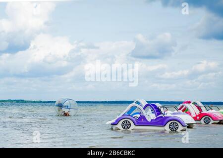 Svityaz- September 2019: colored old vintage plastic catamarans and boats near a wooden pier on the shore of a large lake Stock Photo