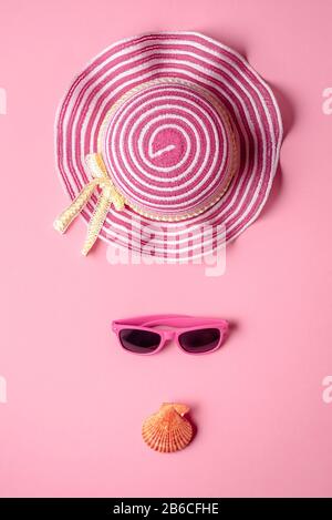 Summer banner with pink hat and sunglasses, on pink seamless background. Colorful beach accessories and seashells. Stock Photo