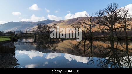 Reflections of trees and the Chinese Bridge seen on Derwent River in the Lake District. Stock Photo