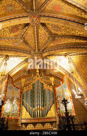 The highly decorated organ pipes & screen beneath vaulted ceiling of the Chapel of St Mary Undercroft in the Palace of Westminster, London, England Stock Photo