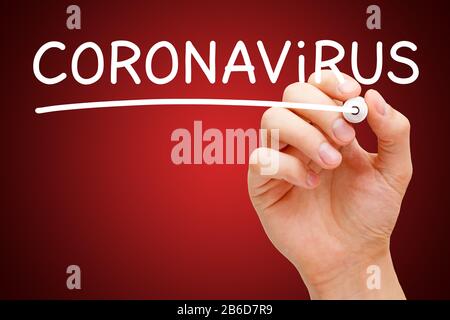 Hand writing word Coronavirus with white marker on transparent wipe board on dark red background. Covid-19 virus epidemic outbreak concept. Stock Photo